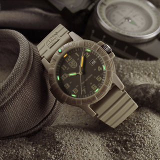 Tactical watch with digital display on a sandy surface