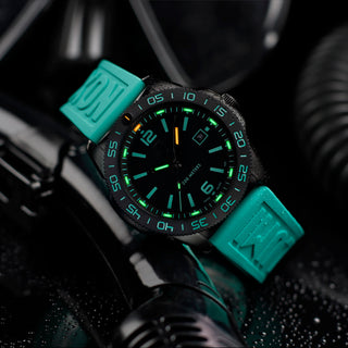 Watch with teal strap on a dark background